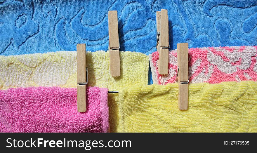 Laundry ( towels of pink, yellow, blue color) on a clothes-line