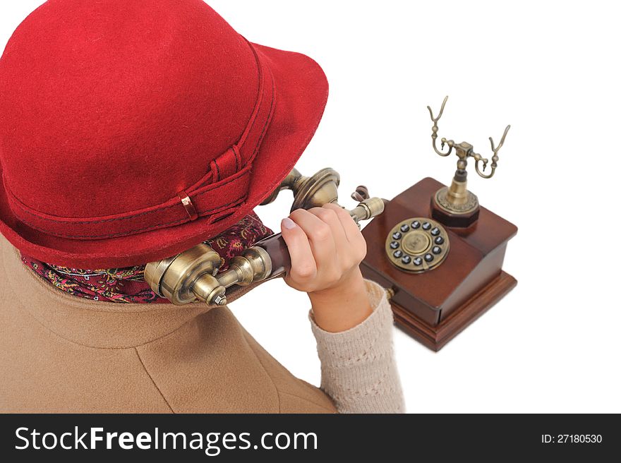 Old-fashioned woman in red hat is talking old-fashioned phone on white isolated background. Old-fashioned woman in red hat is talking old-fashioned phone on white isolated background