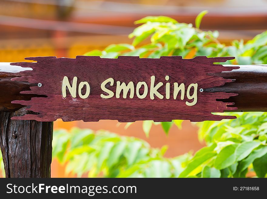 Wooden sign post with words no smoking