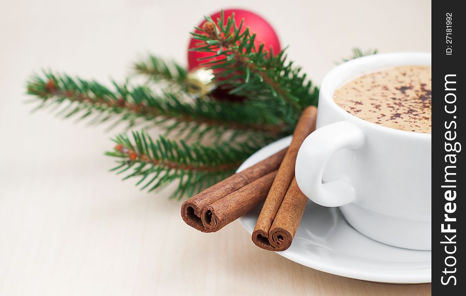 Cup of Christmas cappuccino on holiday background