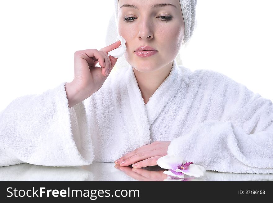 Beautiful woman in a white dressing gown cleaning your face. Beautiful woman in a white dressing gown cleaning your face