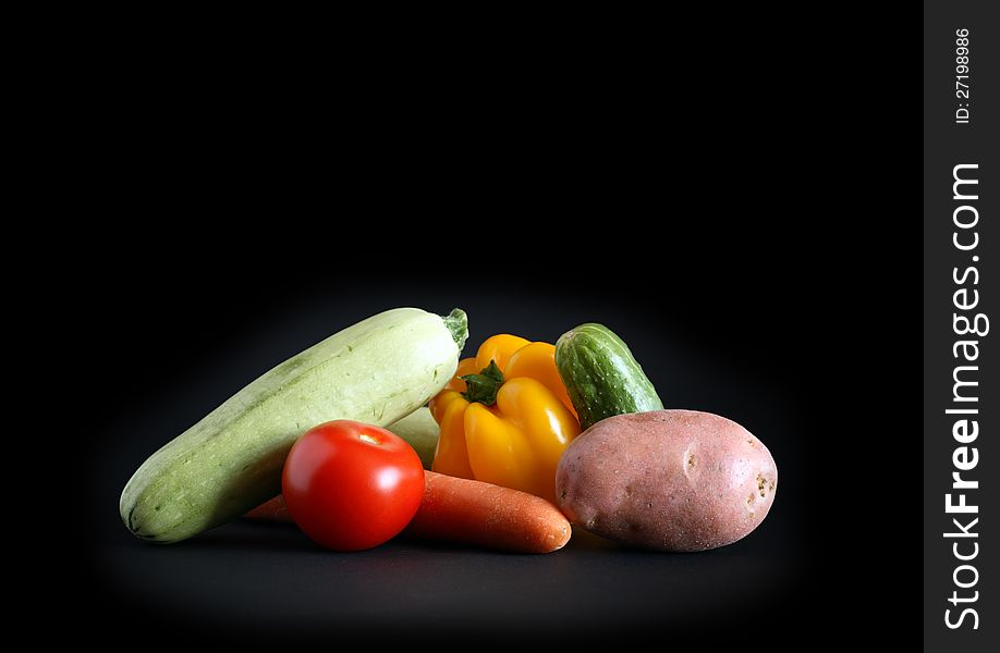 Heap of various raw vegetables on black background