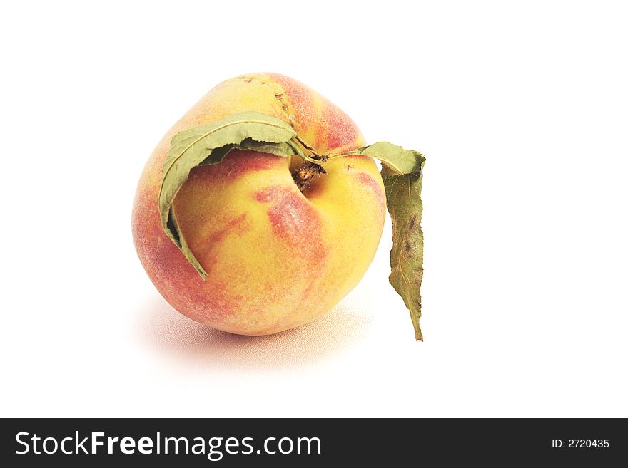 Ripe fresh peach with leaves over white isolated