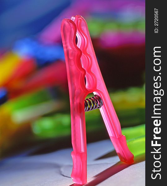 Clothespin of pink color on a blue background