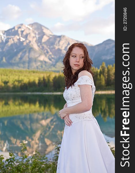 A newly married bride poses for a portrait at Patricia Lake in Jasper National Park, Canada. A newly married bride poses for a portrait at Patricia Lake in Jasper National Park, Canada.