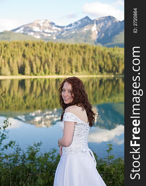 A newly married bride poses for a portrait at Patricia Lake in Jasper National Park, Canada. A newly married bride poses for a portrait at Patricia Lake in Jasper National Park, Canada.