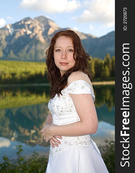 A newly married bride poses for a portrait at Patricia Lake in Jasper National Park, Canada. A newly married bride poses for a portrait at Patricia Lake in Jasper National Park, Canada.