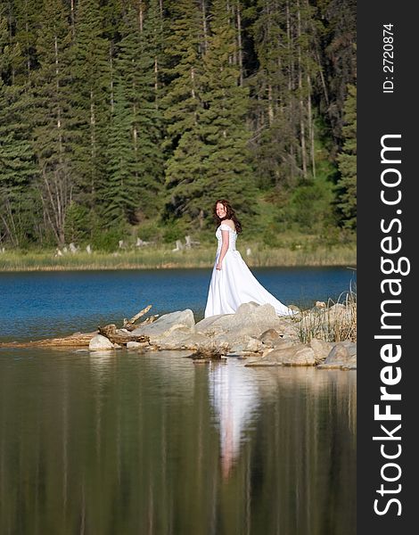 A newly married bride enjoys the shores of Patricia Lake in Jasper National Park, Canada. A newly married bride enjoys the shores of Patricia Lake in Jasper National Park, Canada.