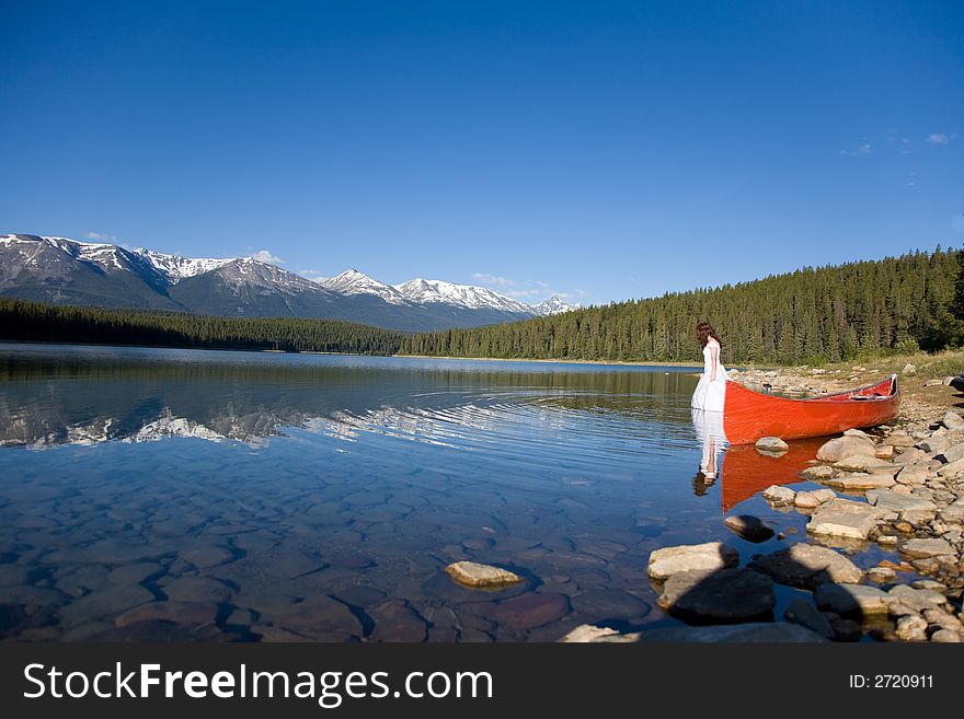 A newly married bride enjoys the waters of Patricia Lake in Jasper National Park, Canada. A newly married bride enjoys the waters of Patricia Lake in Jasper National Park, Canada.