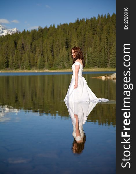 A newly married bride enjoys the waters of Patricia Lake in Jasper National Park, Canada. A newly married bride enjoys the waters of Patricia Lake in Jasper National Park, Canada.