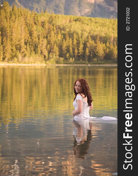 A newly married bride enjoys the waters of Patricia Lake in Jasper National Park, Canada. A newly married bride enjoys the waters of Patricia Lake in Jasper National Park, Canada.