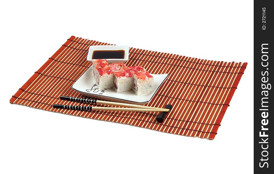 Sushi, soya sauce, chopsticks are located on bamboo mat. Sushi, soya sauce, chopsticks are located on bamboo mat