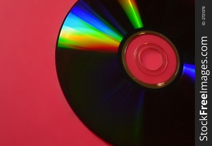 Colourful cd in corner of red backdrop. Colourful cd in corner of red backdrop
