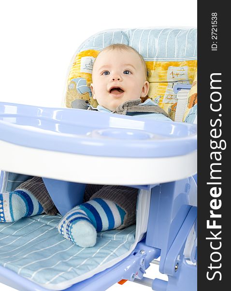 Funny infant smiling and sitting on baby's chair, wearing dungarees. Front view, white background. Funny infant smiling and sitting on baby's chair, wearing dungarees. Front view, white background