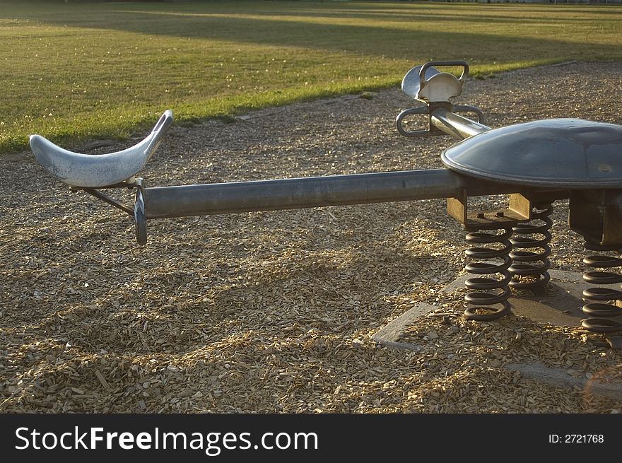 A seesaw in an empty playground just before sunset. A seesaw in an empty playground just before sunset.