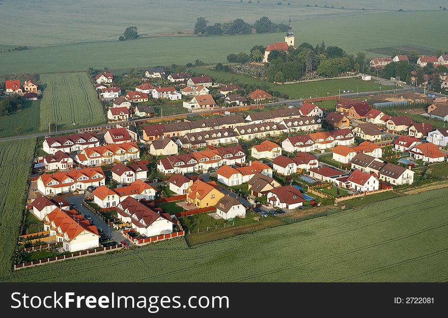 Air view of an old village church surrounded by new estate. Air view of an old village church surrounded by new estate