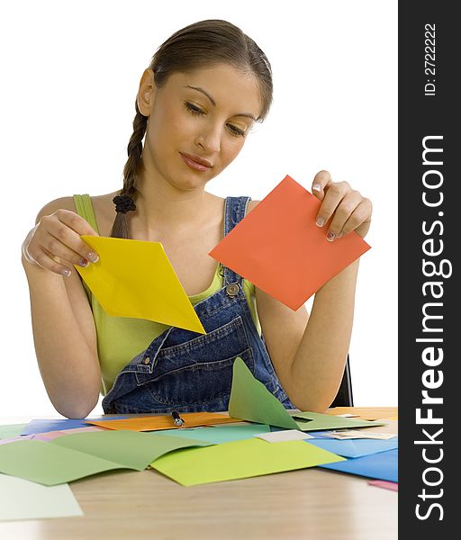 Young, beautiful woman sitting at desk. Holding envelopes and reading something. Front view. White background. Young, beautiful woman sitting at desk. Holding envelopes and reading something. Front view. White background
