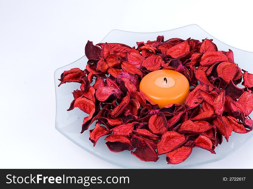 Glass plate with candle and potpourri on the white background. Glass plate with candle and potpourri on the white background