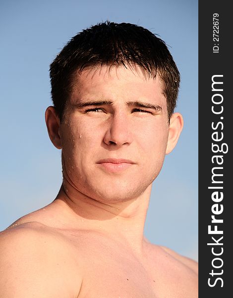 Young man on the beach against the sky