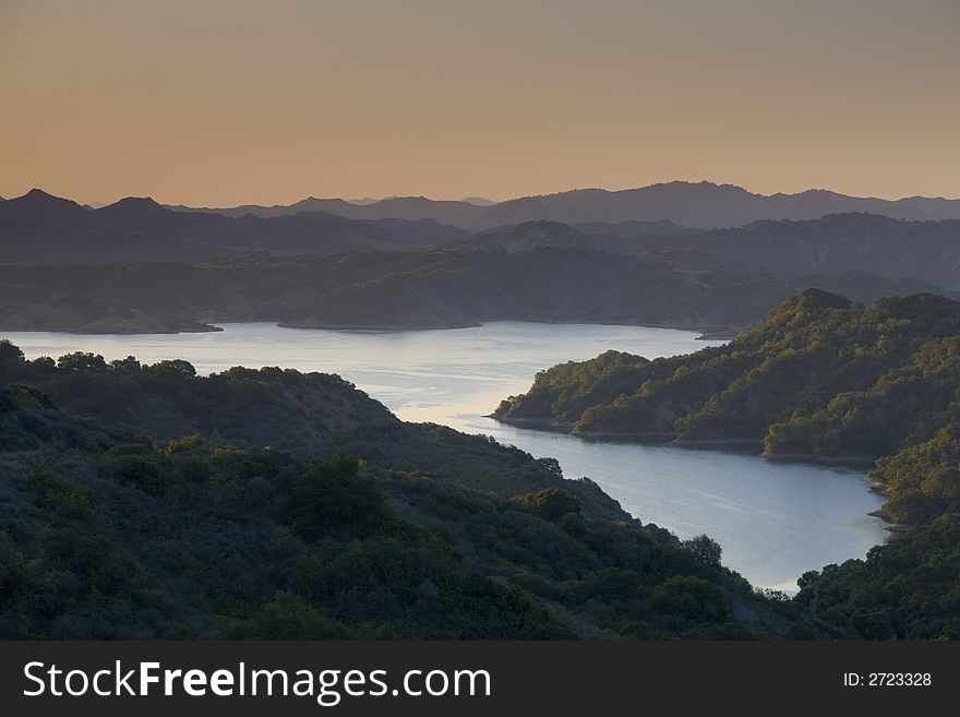 Mountain lake outlined by mountains and sunrise. Mountain lake outlined by mountains and sunrise