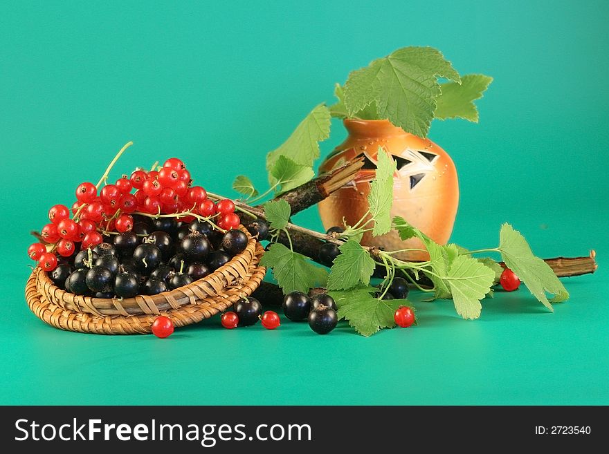 Berries of a red and black currant in a cover and a vase with leaves. Berries of a red and black currant in a cover and a vase with leaves.