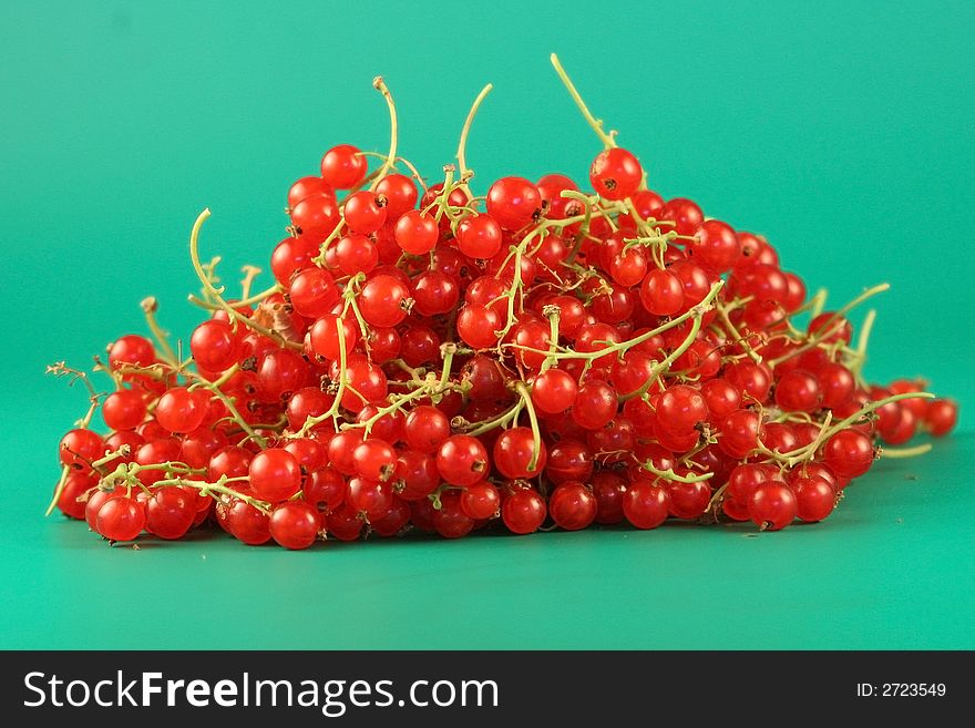 Berries of a red currant is photographed close up on a green background. Berries of a red currant is photographed close up on a green background.