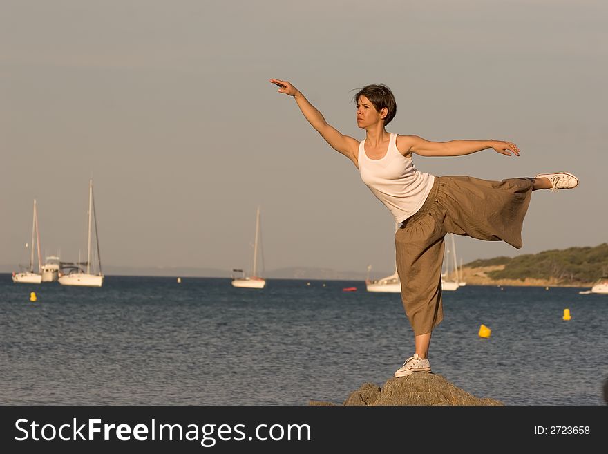 Woman making a exercise of balance at the seaside. Woman making a exercise of balance at the seaside