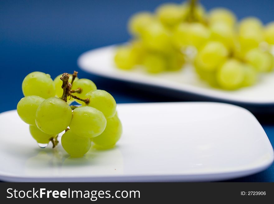 Multiple white grapes on 2 different plates. Multiple white grapes on 2 different plates.