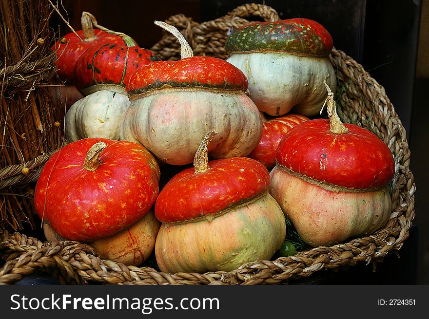 An ornamental basket with  seven pumpkins. An ornamental basket with  seven pumpkins