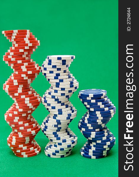 Stacked jetons isolated on green poker table felt. Stacked jetons isolated on green poker table felt.