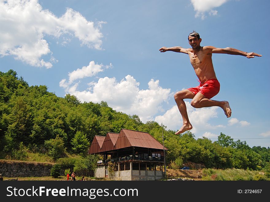 Man jumping in green river. Man jumping in green river