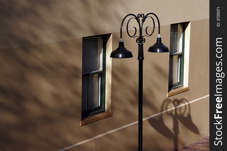 Classic Black Street Light In Front Of A House Wall, Shadows, Windows. Classic Black Street Light In Front Of A House Wall, Shadows, Windows