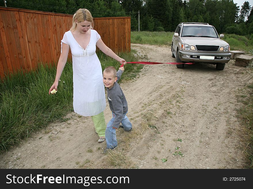 Mother with the son they pull automobile on the rope. Mother with the son they pull automobile on the rope