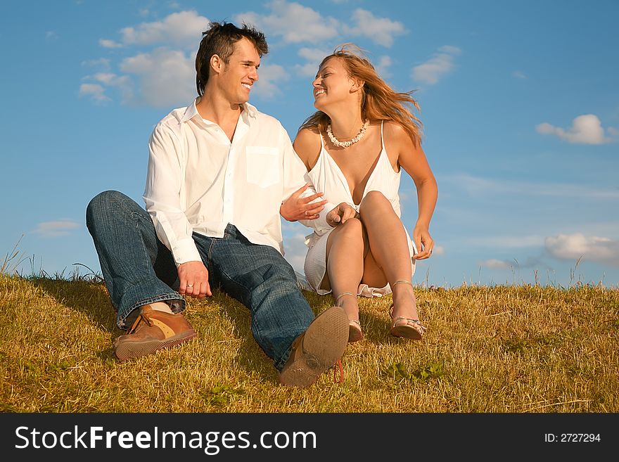 Couple sits on the meadow