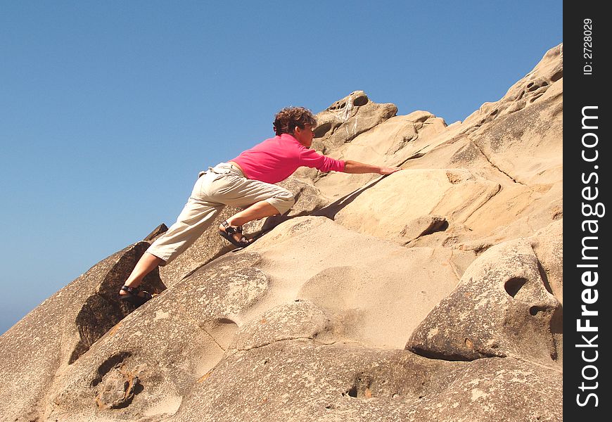 Young Woman climbing a rock wall. Young Woman climbing a rock wall