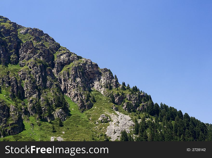 Mountain scenery with forest and rocky slopes. Mountain scenery with forest and rocky slopes