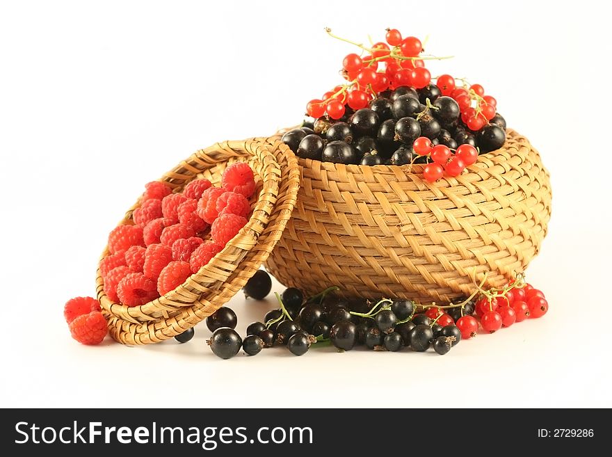 Berries of raspberry, a red and black currant in a basket  isolated on white. Berries of raspberry, a red and black currant in a basket  isolated on white.