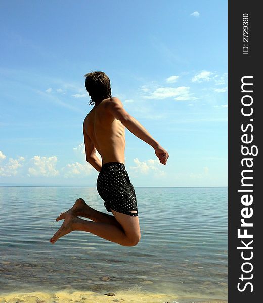 The young man has jumped up on a background of the sea
