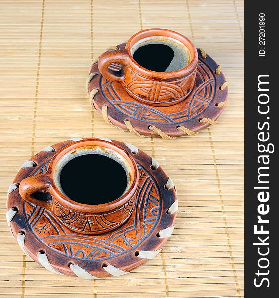 Two cups of coffee on a mat