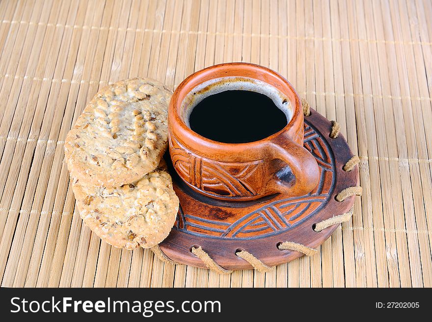 Cup of coffee and cookies on a mat