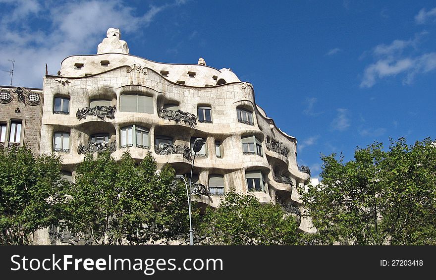 Mila house, designed by Gaudì in Barcelona, external view of the upper part above the treetops. Mila house, designed by Gaudì in Barcelona, external view of the upper part above the treetops