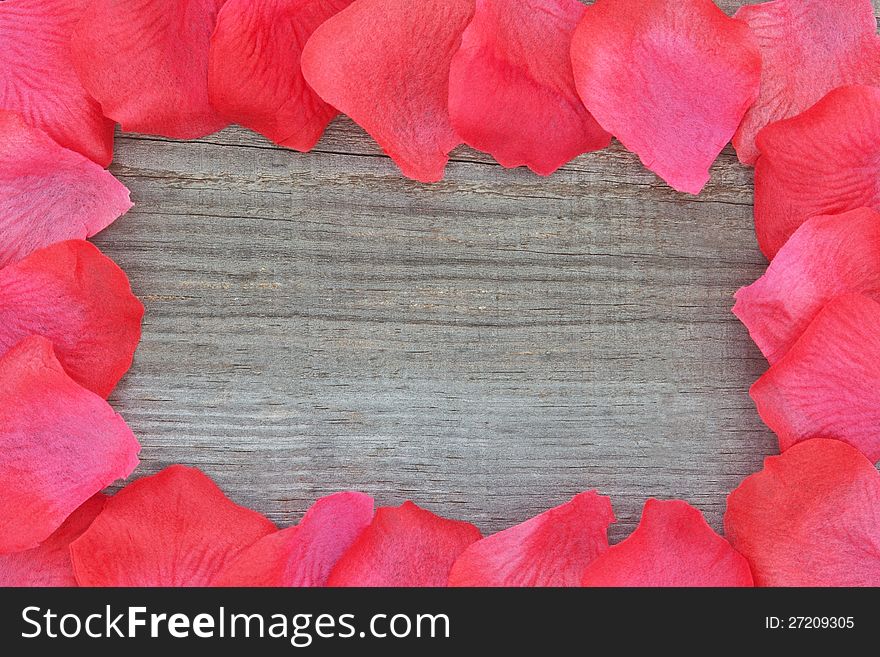 Rose petals on textured wood. Closeup.