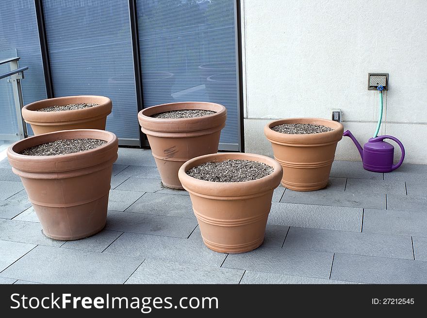 A balcony of an office building have pots with flower seeds. A balcony of an office building have pots with flower seeds.