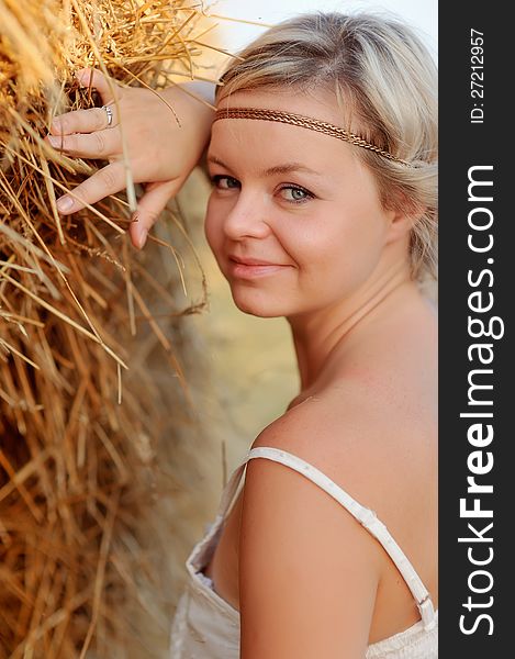 Beautiful girl with blond hair lying on hay. Beautiful girl with blond hair lying on hay