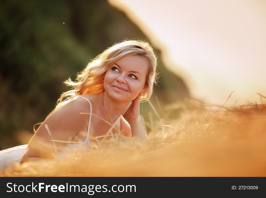 Beautiful girl with blond hair lying on hay. Beautiful girl with blond hair lying on hay