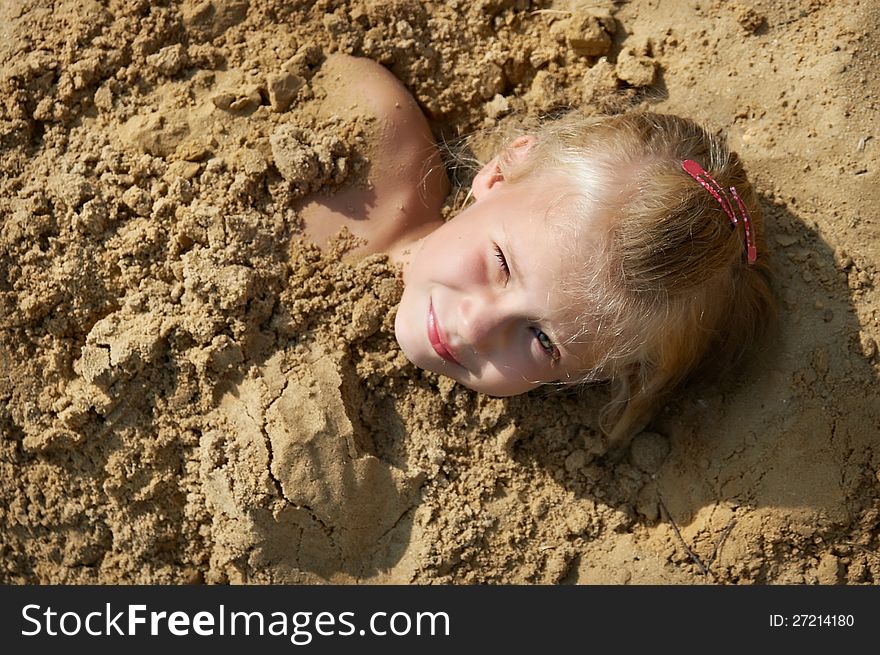 Little girl lying on sand