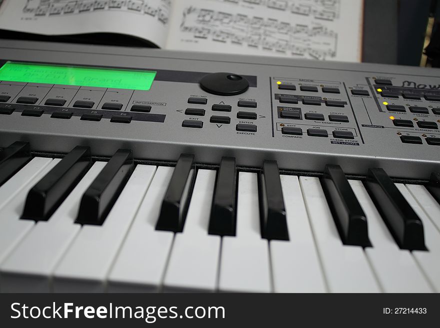 Synthesizer and music on a stand behind the keyboard. Synthesizer and music on a stand behind the keyboard