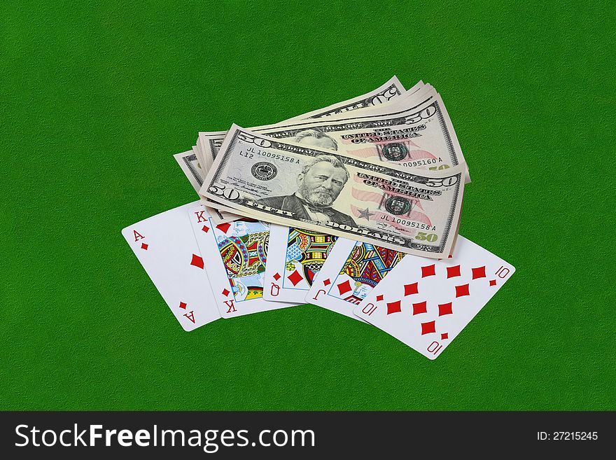 Royal flush combination and thousand of US dollars on green cloth table. Royal flush combination and thousand of US dollars on green cloth table