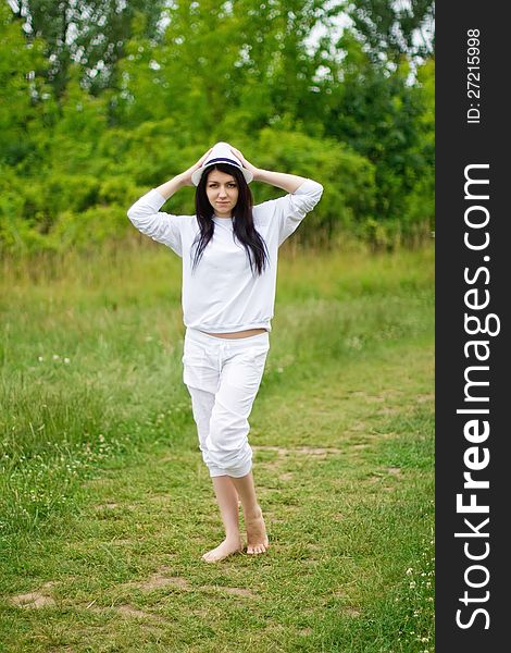 A young girl standing in the green grass area. A young girl standing in the green grass area