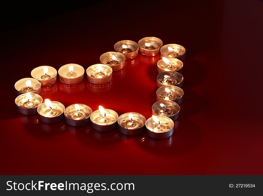 Love concept. Heart made from lot of lighting candles. Love concept. Heart made from lot of lighting candles